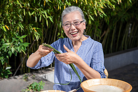 端午节奶奶户外包粽子图片