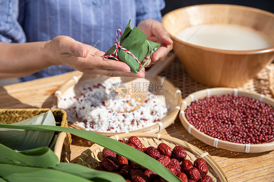 端午节户外奶奶包粽子特写图片