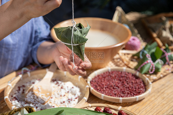 端午节户外奶奶包粽子特写图片