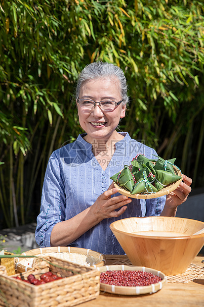 端午节奶奶户外拿着粽子图片