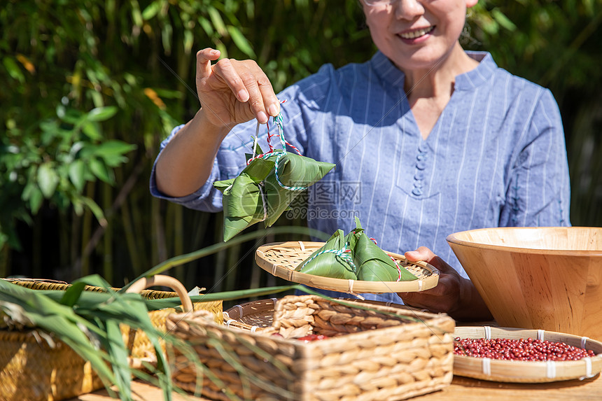 端午节奶奶户外拿着粽子图片