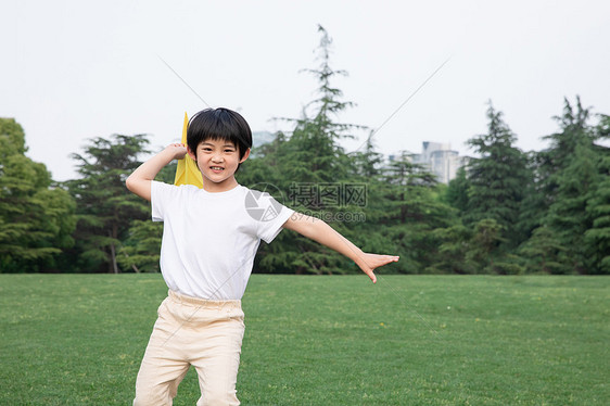 户外飞纸飞机的小男孩图片