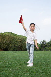 户外飞纸飞机的小女孩图片