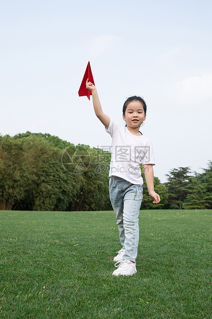 户外飞纸飞机的小女孩图片