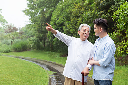 儿子搀扶父亲拄拐逛公园图片