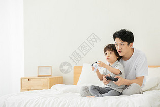 父子居家床上玩电子游戏图片