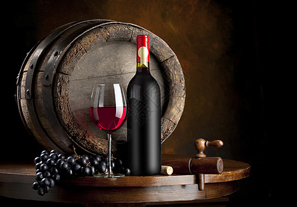 红酒瓶放在酒窖橡木桶前的红酒和盛有红酒的红酒杯背景