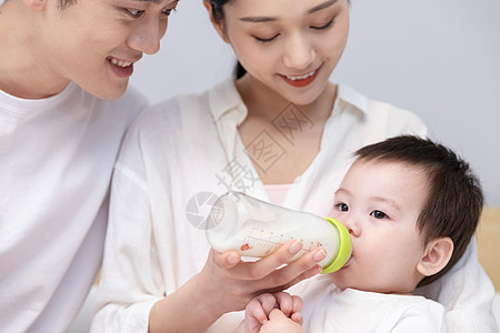 一家三口爸爸妈妈喂婴儿喝奶图片