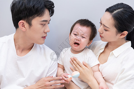 一家三口哄哭泣的婴儿图片