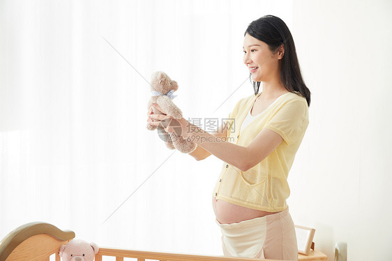 孕妇拿着玩偶微笑图片