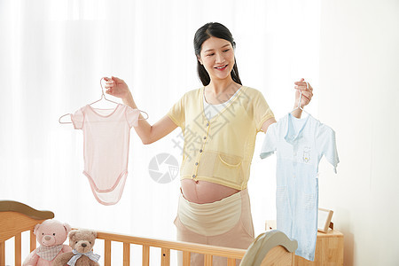 孕妇拿着宝宝衣服图片