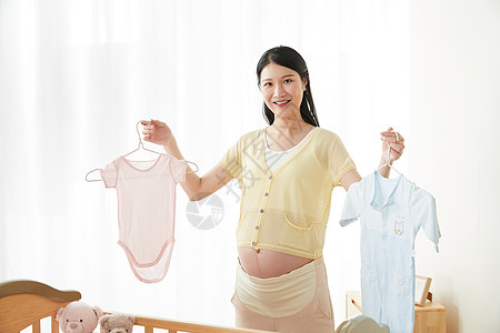 孕妇做饭孕妇拿着宝宝衣服背景