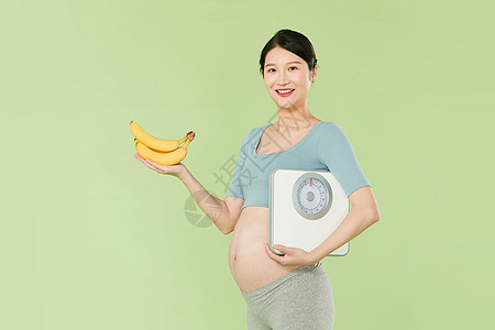 孕妇拿着香蕉和体重秤图片