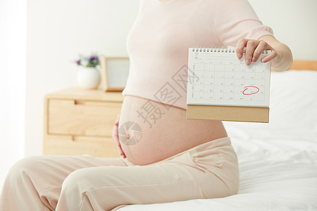 母亲节日历孕妇拿着日历展示预产期背景