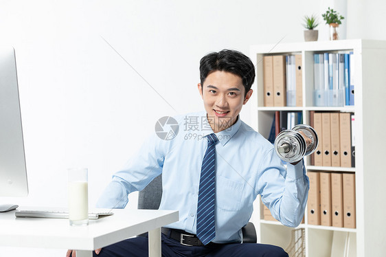 商务男士在办公室用哑铃健身图片