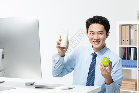 年轻商务男士在办公室喝牛奶图片