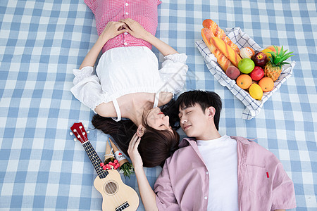 青年情侣躺在野餐垫上图片