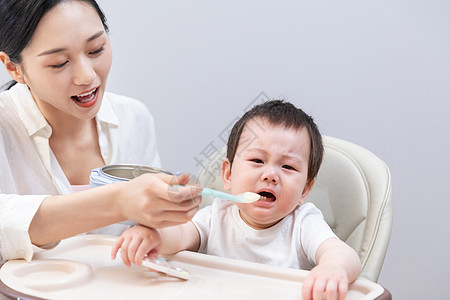 妈妈喂哭闹的婴儿吃东西图片