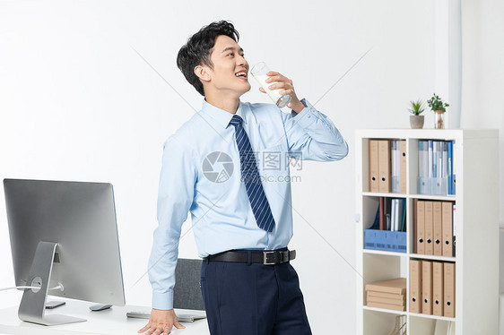 青年商务男性办公室喝牛奶图片