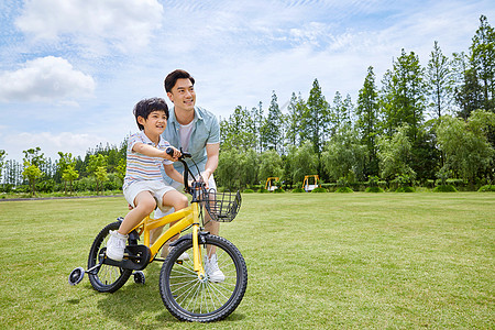 家庭保护爸爸带着小男孩骑单车背景