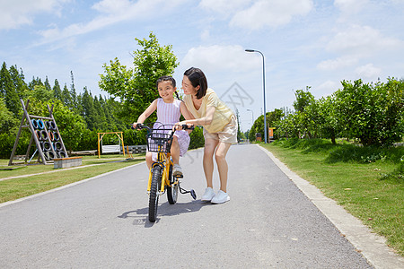 妈妈教小女孩骑单车图片