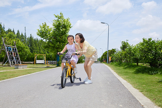 妈妈陪伴女儿骑自行车图片