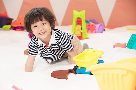 麦叶上小孩趴在白色沙滩上的小男孩背景