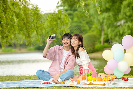 青年情侣野餐拍照自拍图片