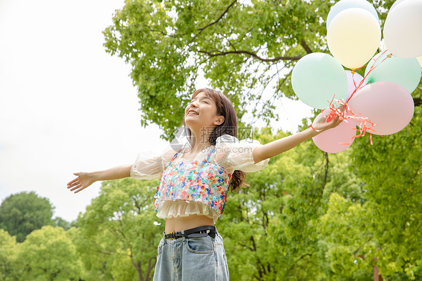 青年女性公园拿着气球图片