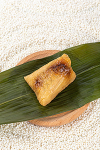 新鲜好吃的粽子放置在糯米上图片