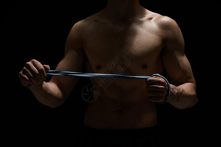 使用拉力绳健身训练的运动男性背景图片
