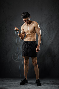 使用拉力绳健身训练的运动男性图片