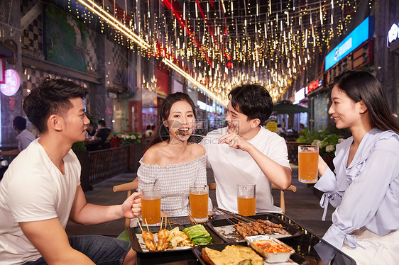 青年朋友聚会吃夜宵喝啤酒图片