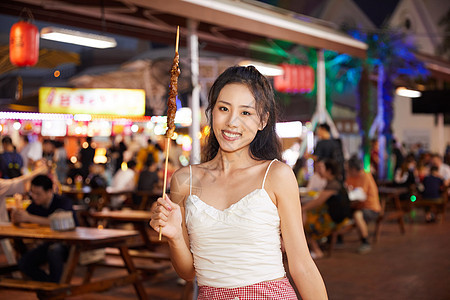 美女逛夜市品尝特色羊肉串图片