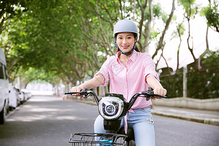 青年女性户外骑电动车高清图片