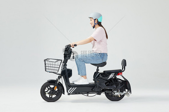青年女性戴头盔骑电动车图片