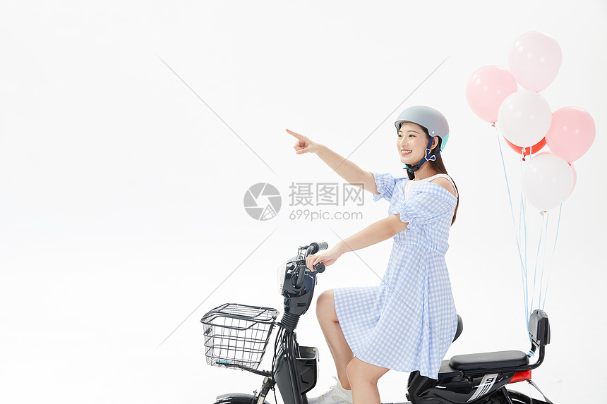 青年女性戴头盔骑电动车图片