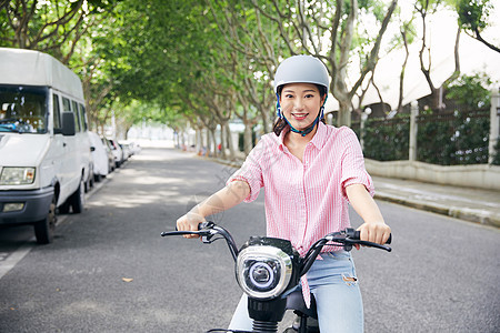 美女骑电动车低碳出行背景图片