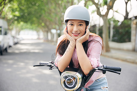 美女户外骑电动车戴头盔背景图片