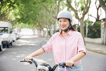 美女骑电动车低碳出行背景图片