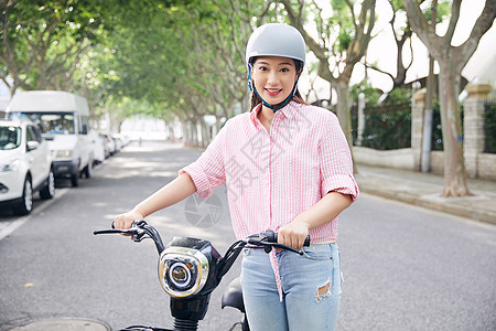 美女骑电动车低碳出行背景图片