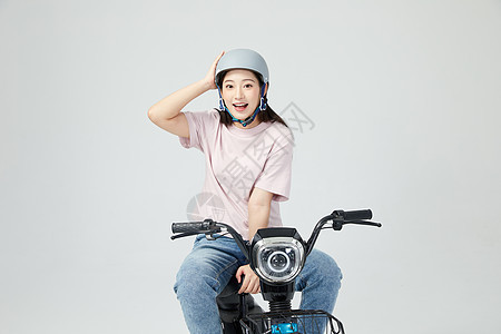 美女骑电动车戴头盔背景图片