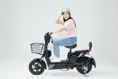 美女戴头盔骑行电动车背景图片