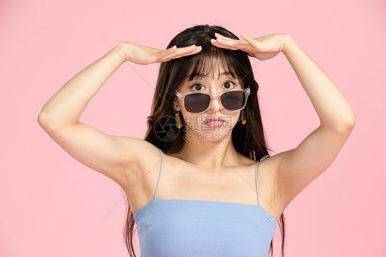 青春时尚活力女性戴墨镜遮挡太阳光线图片