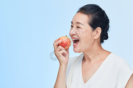 老年女性咬苹果图片