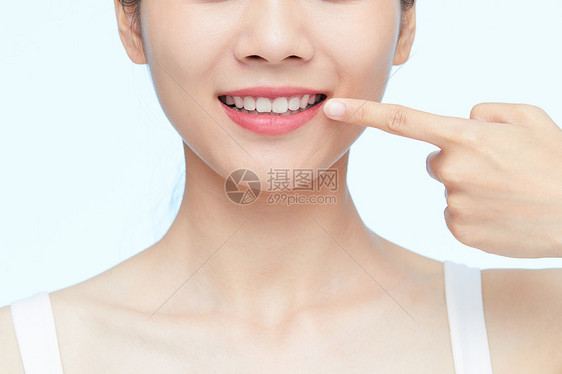 年轻女性用手指牙齿特写图片