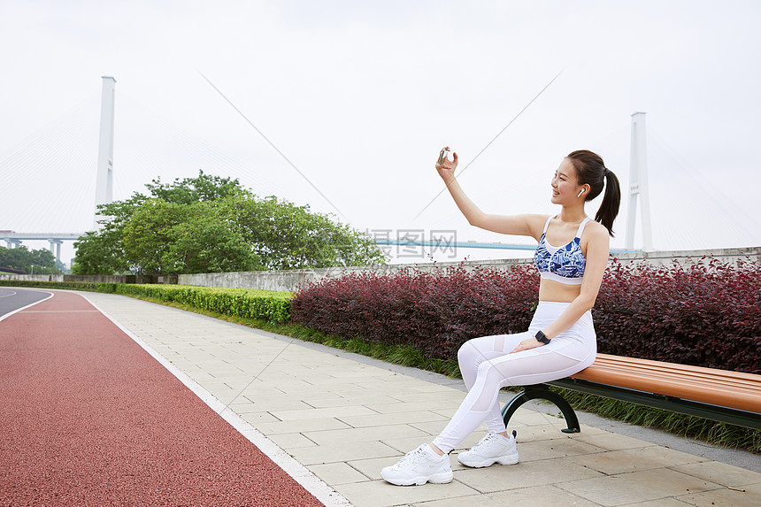 美女坐在公园长椅上自拍图片