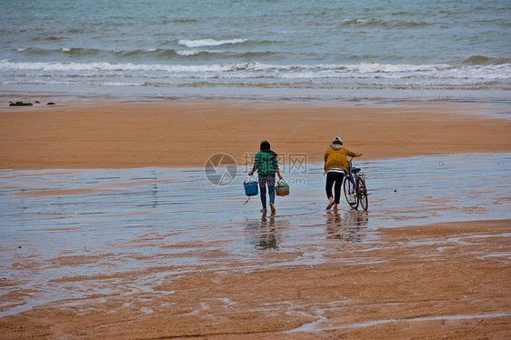 海边沙滩上赶海的妇女图片