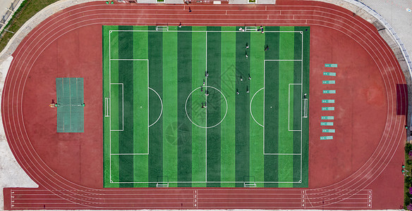 俯拍校园球场学生踢足球图片