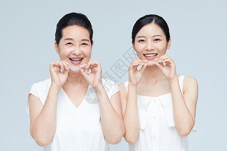 年轻美女和中年女性一起手拿牙套展示图片